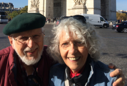 mature man and woman next to a banner of a historical site